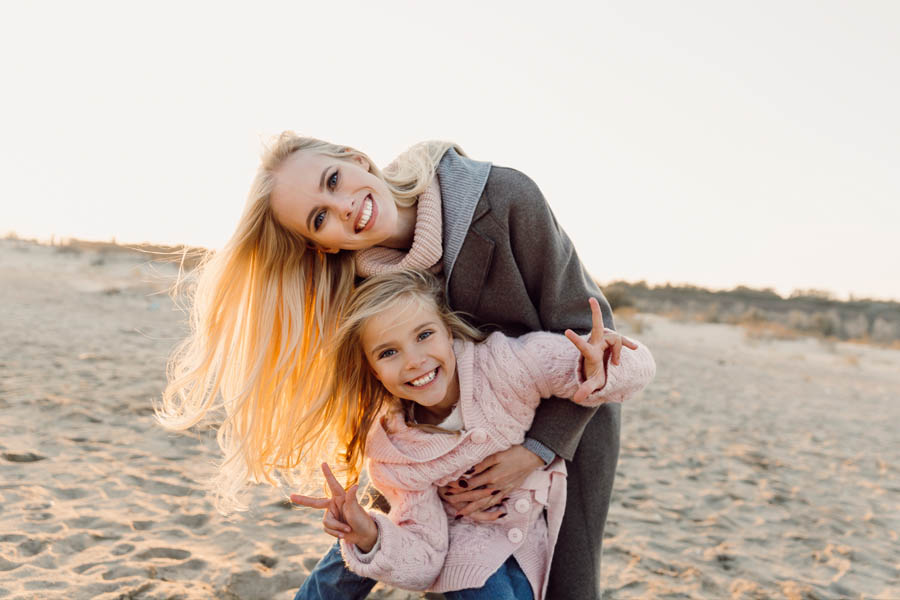 Client Center - Mother and Daughter with Coats on Hanging Out at the Beach on a Sunny Day